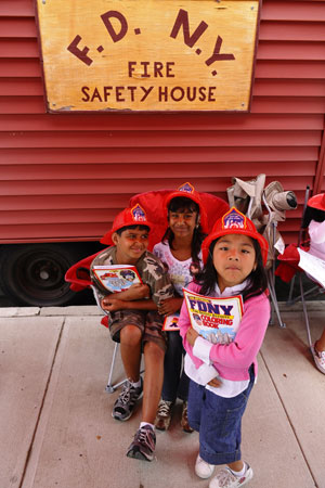 Students learn fire evacuation techniques in the FDNY's Fire Safety House.