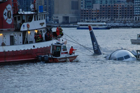 Marine 1 tethers the airplane while it floats down the Hudson River. At the time, the water temperature was near freezing.