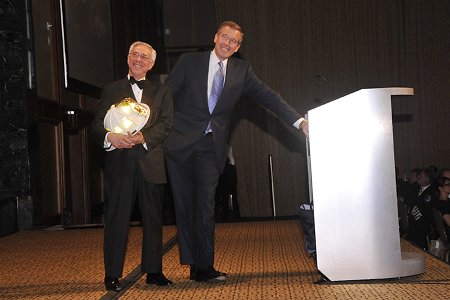 Honoree Brian Williams (right) watches a video tribute during the Humanitarian Awards along with Colonel Jack Jacobs, the award presenter.
