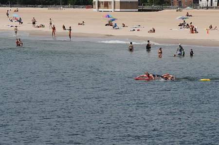 A firefighter swims to a victim on a rescue surfboard.