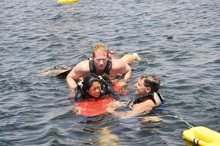 Capt. Joe Matthews and FF Mike Romano from the surf training unit rescue a simulated victim (Nina Pineda from ABC 7 News) using a rescue surfboard.