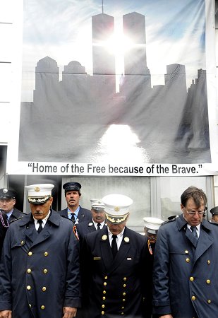 (L to R) Manhattan Borough Commander Chief Michael Weinlein, Chief of Department Salvatore Cassano and First Deputy Commissioner Frank Cruthers join firefighters outside Engine 10/Ladder 10, across the street from the World Trade Center site, during the annual Sept. 11 memorial service.