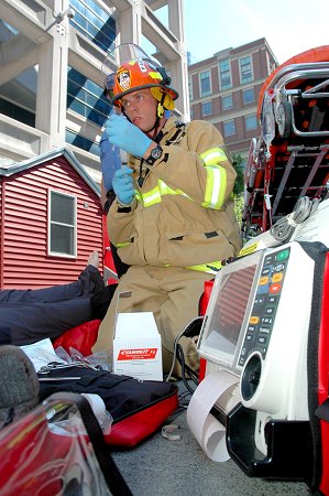 A paramedic treats the victim (a high-tech mannequin) of smoke inhalation and cyanide poisoning.