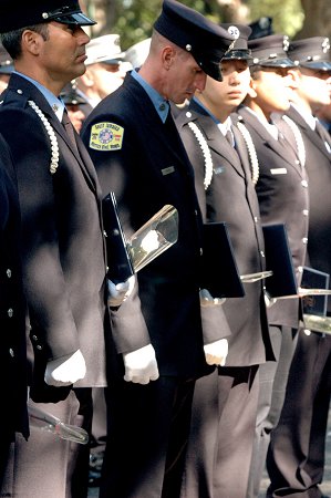 Firefighters hold flowers and certificates presented to family members of the 14 FDNY members who died in the last year.