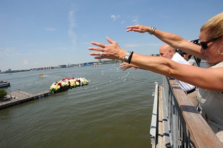 Fire Commissioner Salvatore Cassano and President of the Intrepid Museum Susan Marenoff throw a wreath into the Hudson River to commemorate the Blessing of the Fleet ceremony.