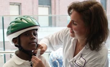 Bellevue Hospital Dr. Deborah A. Levine adjusts the helmet for Dwayne Sanders for a good fit.