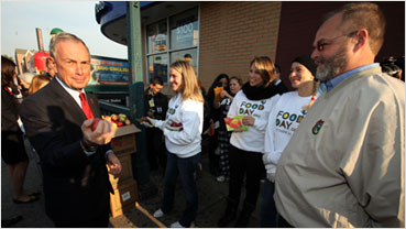 Mayor Bloomberg distributes New York State apples to commuters at the Steinway Street subway station.