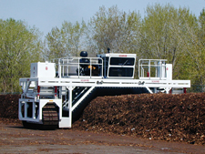 photo: a windrow turner processing the decomposing material