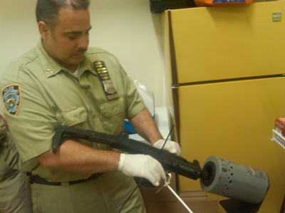 Officer Charles La Vine checks an Uzi submachine gun Officer Charles La Vine checks an Uzi submachine gun