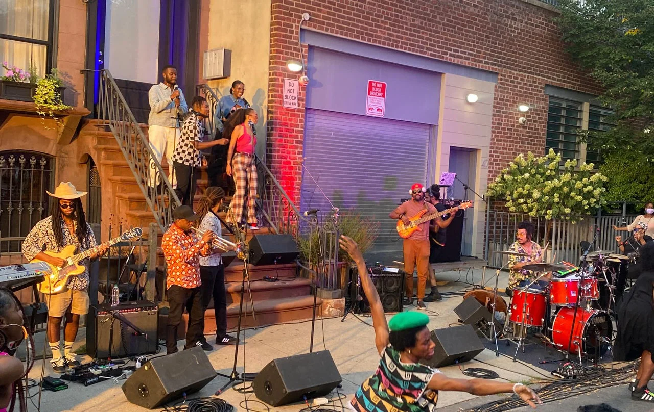 A group of musicians performs on a street.