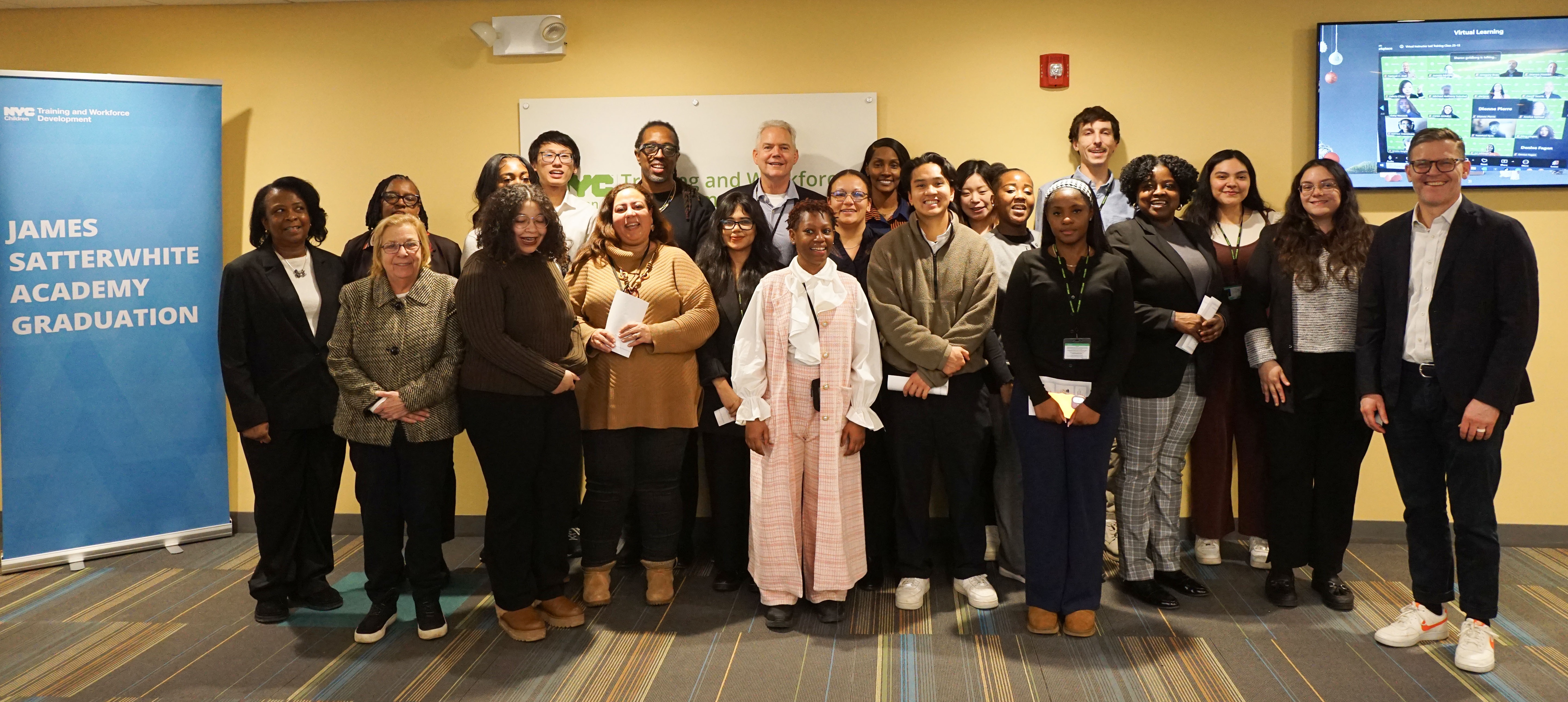 A group of graduates pose for a photo in an auditorium.