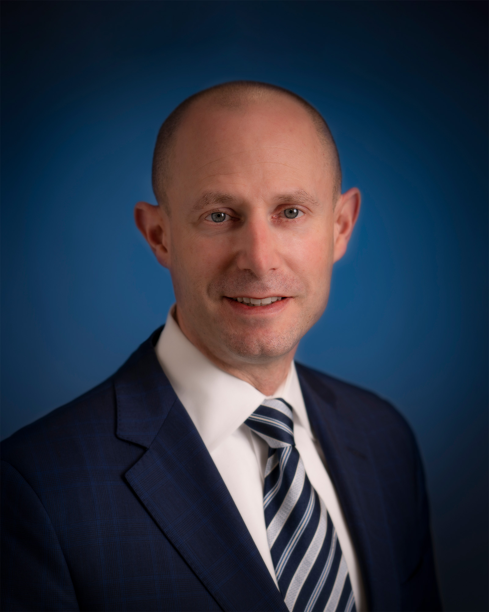 Portrait of Alan W. Sputz in a suit, smiling for a photo