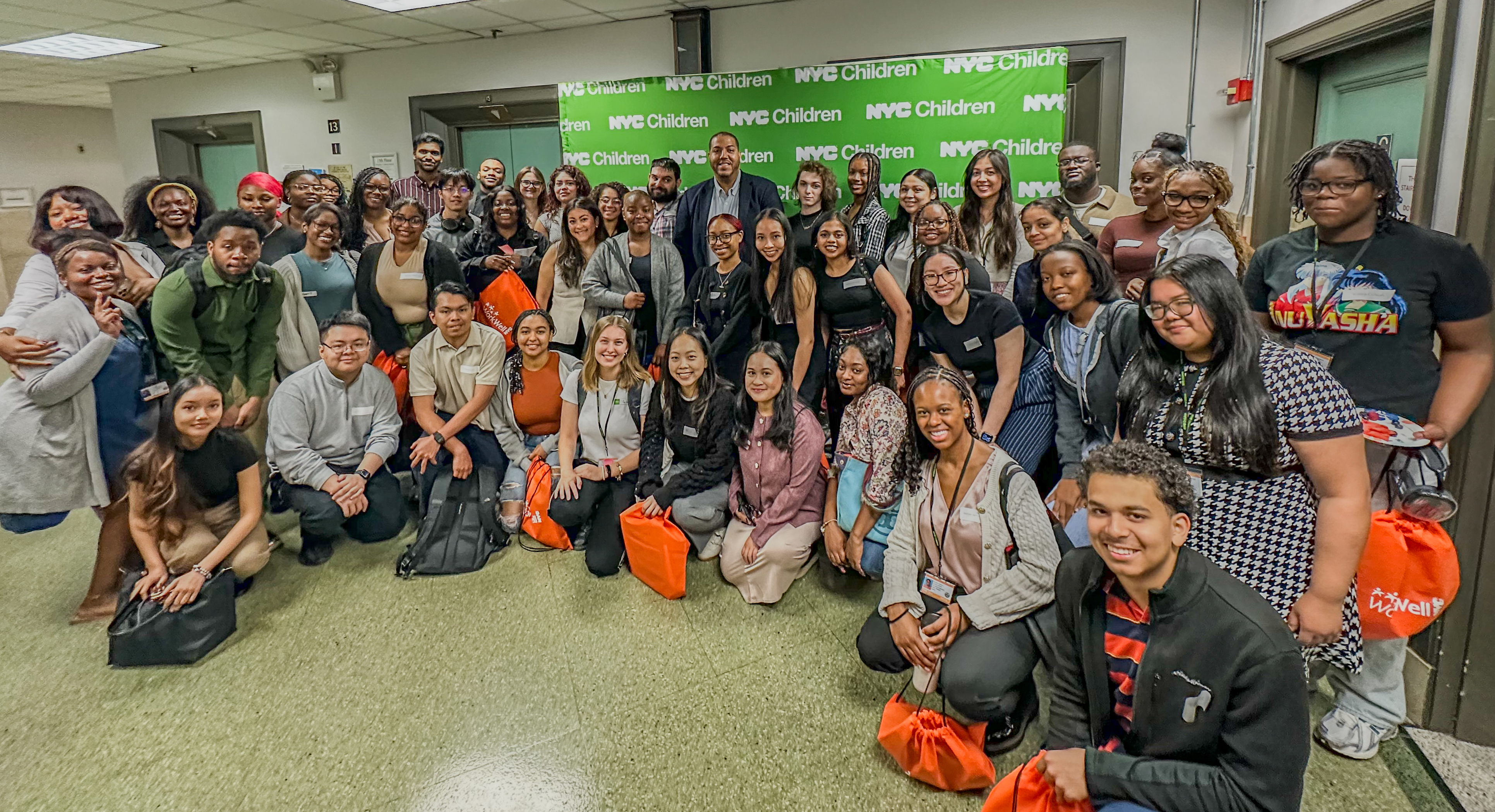 Staff and interns are gathered in a room, smiling for a group photo
