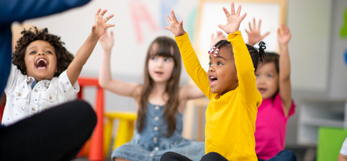 Four children with their hands up