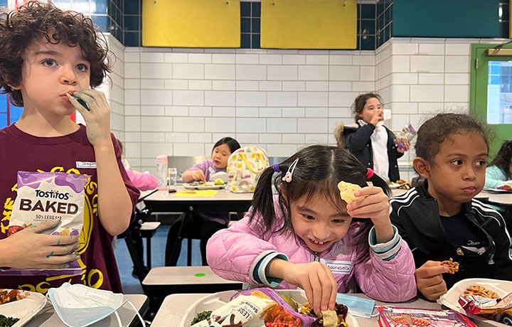 A group of kid are eating lunch at the PS 130
                                           