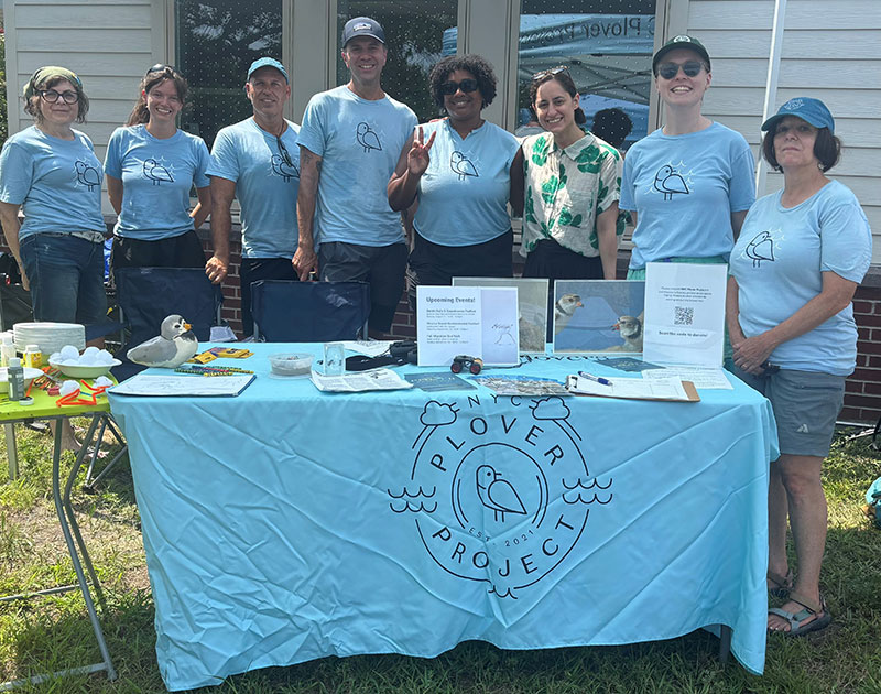 Photo of the Director of the Mayor’s Office of Animal Welfare and the NYC Plover Project team standing behind a table with the Plover Project banner