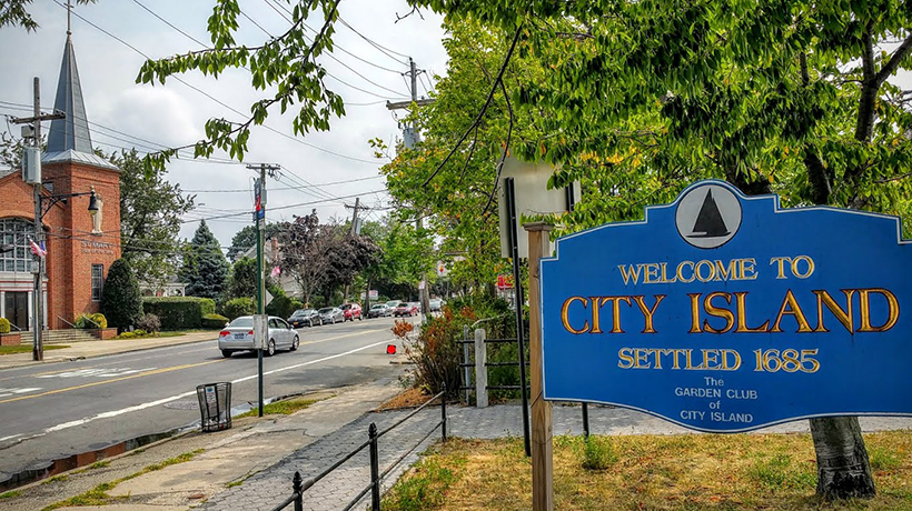 blue sign on street that reads Welcome to City Island settled 1685, the garden club of city island
                                           