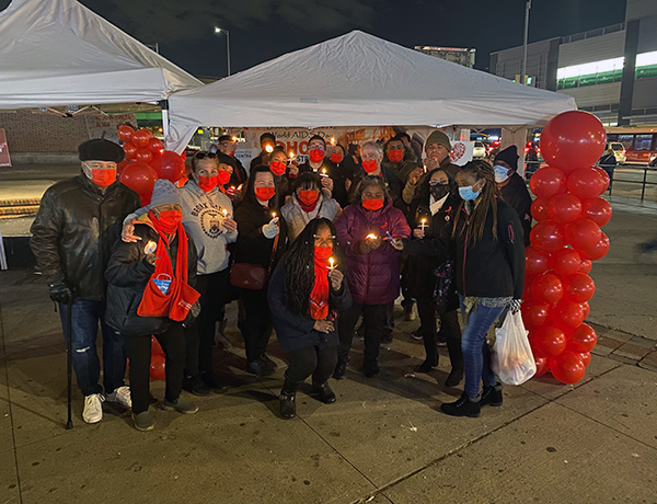 members of Bronx community board 2 holding candles in front of white tent
                                           