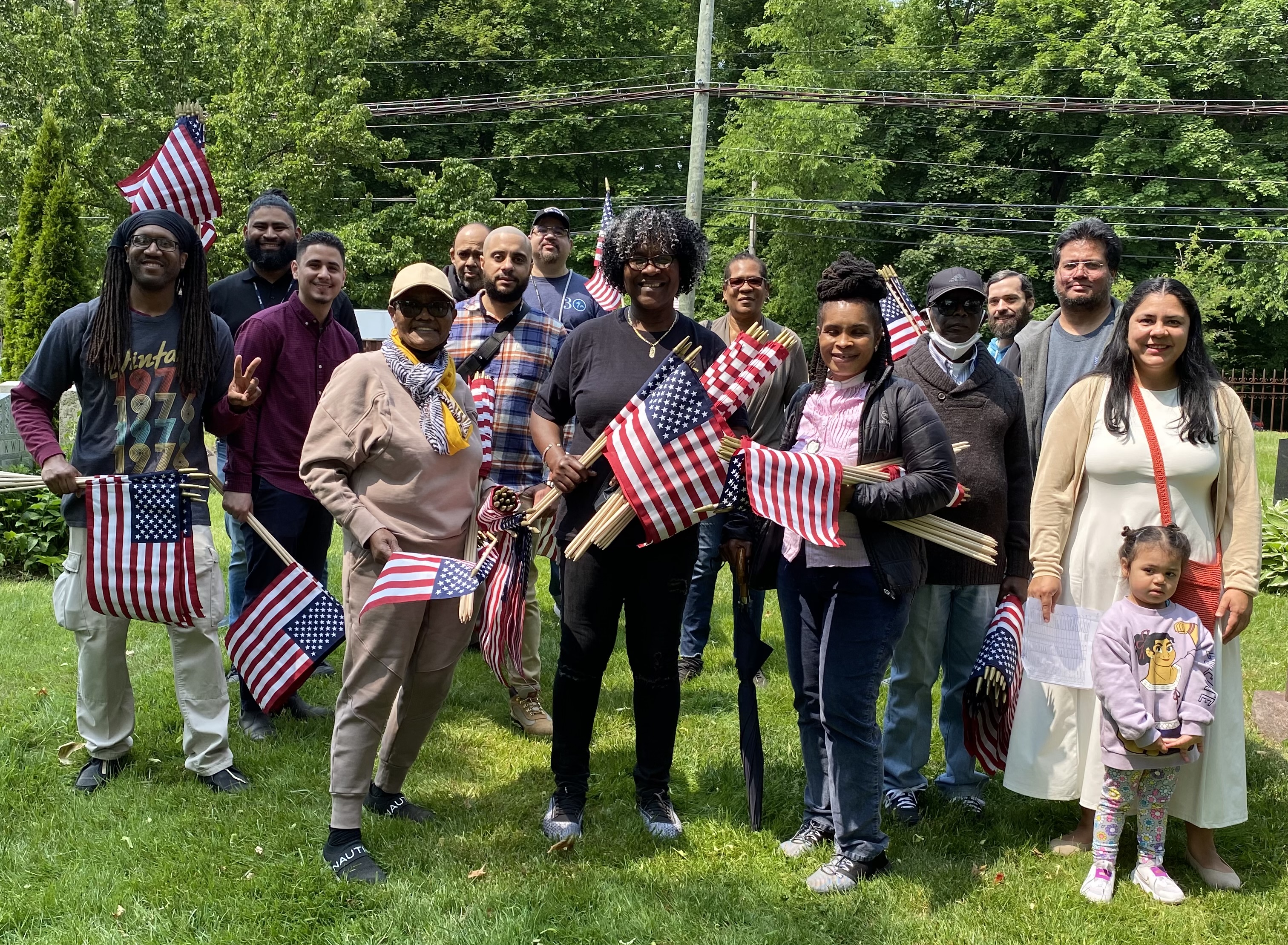 Group of BXCB7 members standing and smiling on grass outside at event
                                           