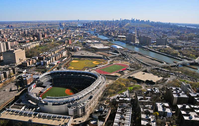 Aerial view of Yankee stadium, Bronx Courthouse, highways, streets, Hudson River, Manhattan skyline view in the distance.