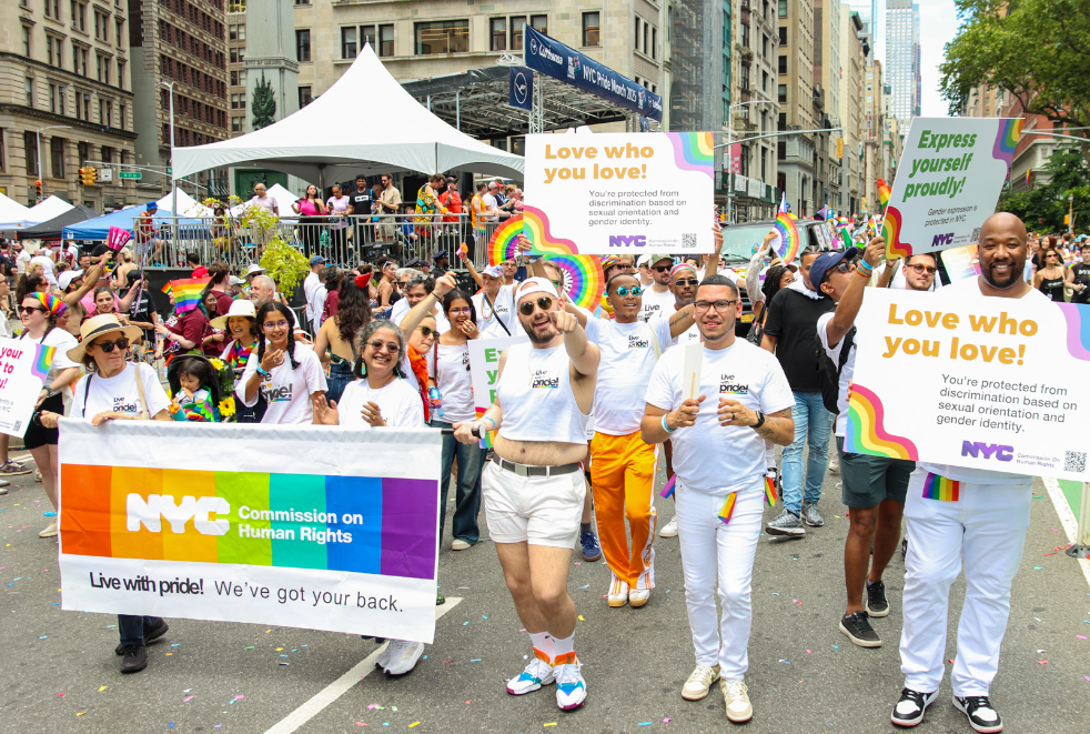 Several members of Commission staff marching at parade with a banner that reads NYC Commission on Human Rights, Live with Pride, We've Got Your Back