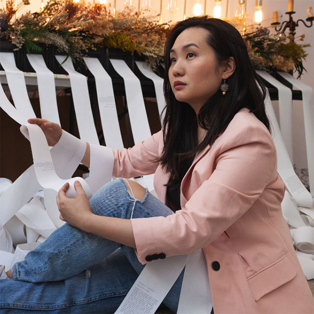 Photo of Asian women sitting in front of art installation