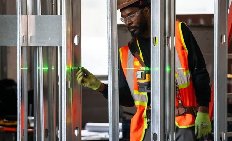 A man wearing a safety vest is working on a construction site. Description generated by AI