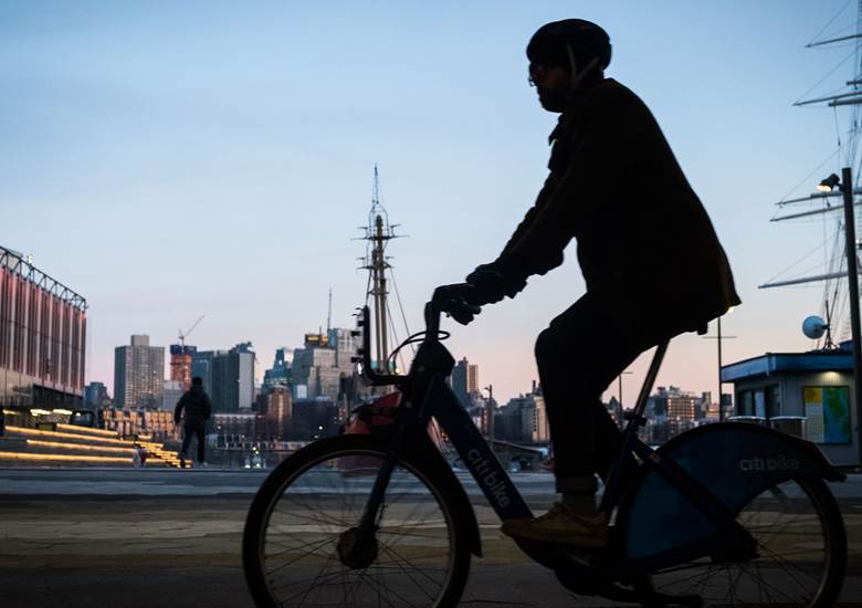 A man riding a bike in a city. Description generated by AI