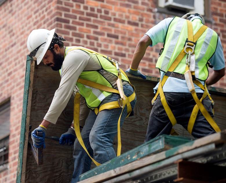 Two men working on a building. Description generated by AI