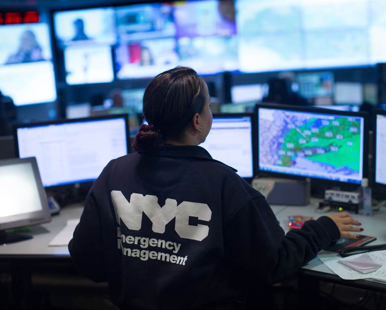 A woman in a NYC Emergency Management uniform is working at a computer. Description generated by AI