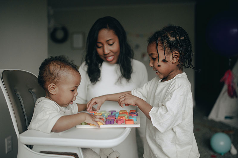 Photo of two children and their care provider.