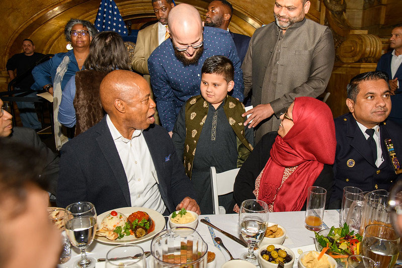 mayor adam is talking to a kid at the dinner table