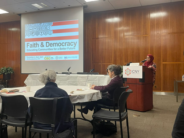 Photograph of keynote speaker, Dr. Sarah Sayeed from NYC CEC at a podium during the 'Faith & Democracy' event held at ICNY (Interfaith Center of New York)