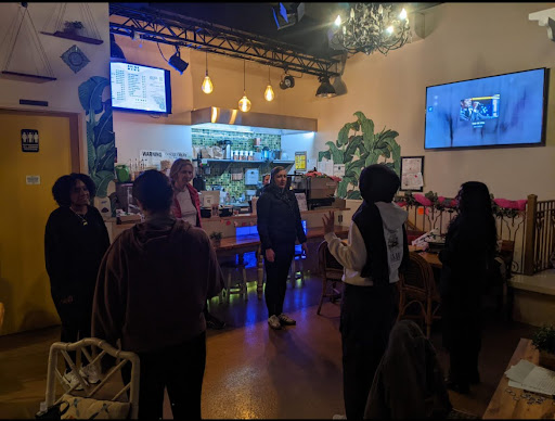 6 women gathered together inside a café for a self-defense training