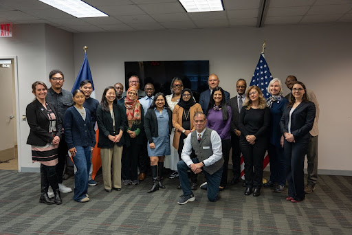 Language Assistance Advisory Committee comprised of 12 representatives pictured infront of City of New York and United States Flags