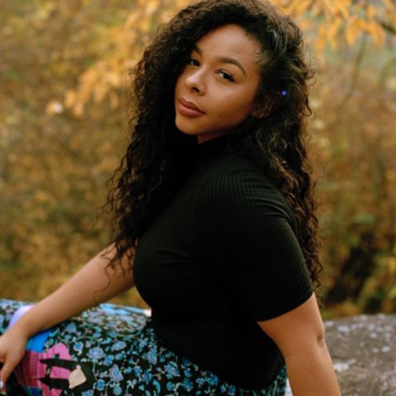 Civic leader: Photo of Sutton King posing, wearing a black shirt and colorful bottoms.