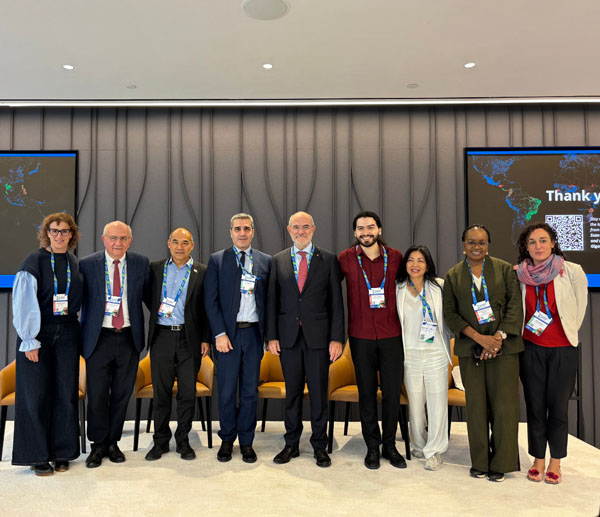 Oscar Romero posing with other panelists on stage from the Living Labs talk at the Science Summit.