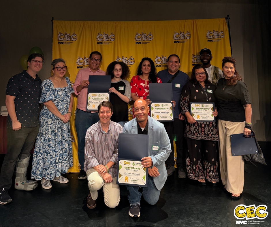 Photo of 11 CEC staff and partners posing in front of a yellow CEC background, with partners holding up award certificates