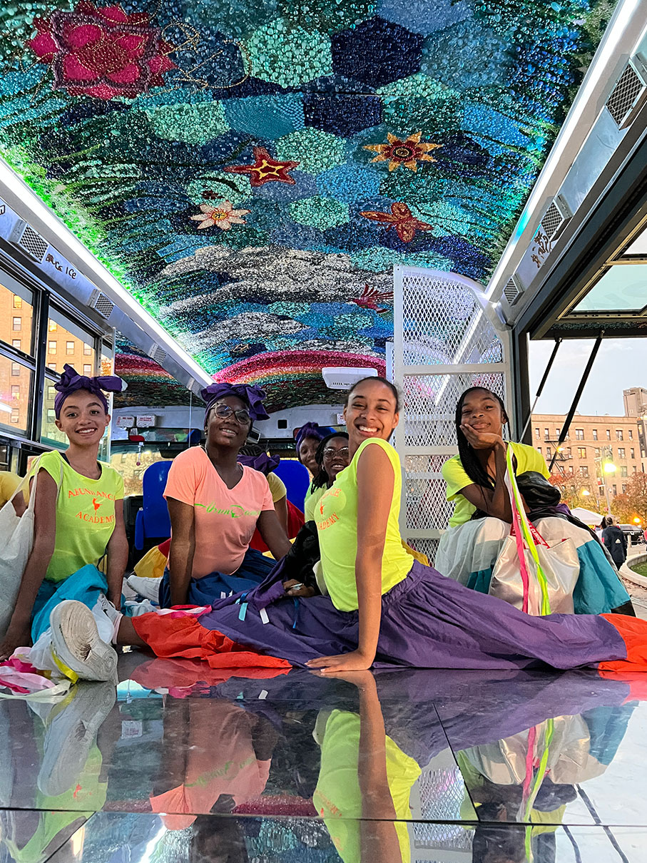 Group of young dancers sitting inside the bus