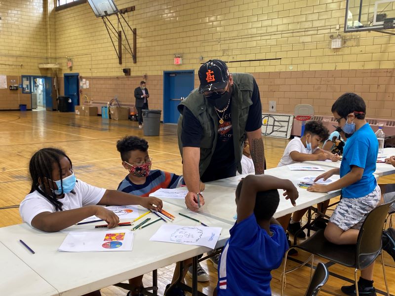 the artist Caffetti helping kids create art at a workshop in the bronx