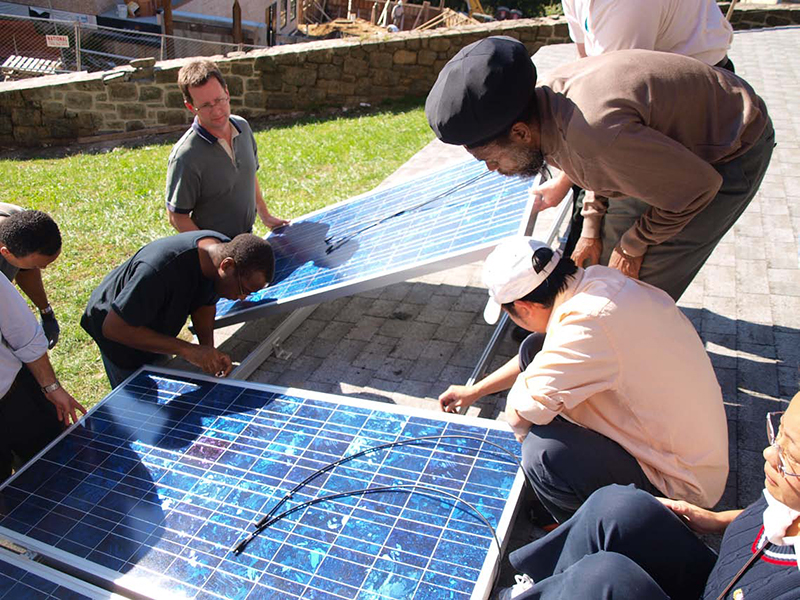 college students learning how to install solar panels