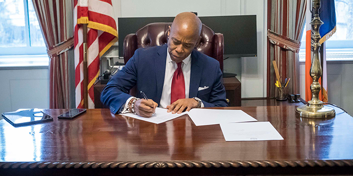 Photo of Mayor Adams signing an Executive Order