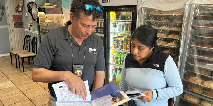 DCWP staff member reads over an inspection checklist with a small business owner