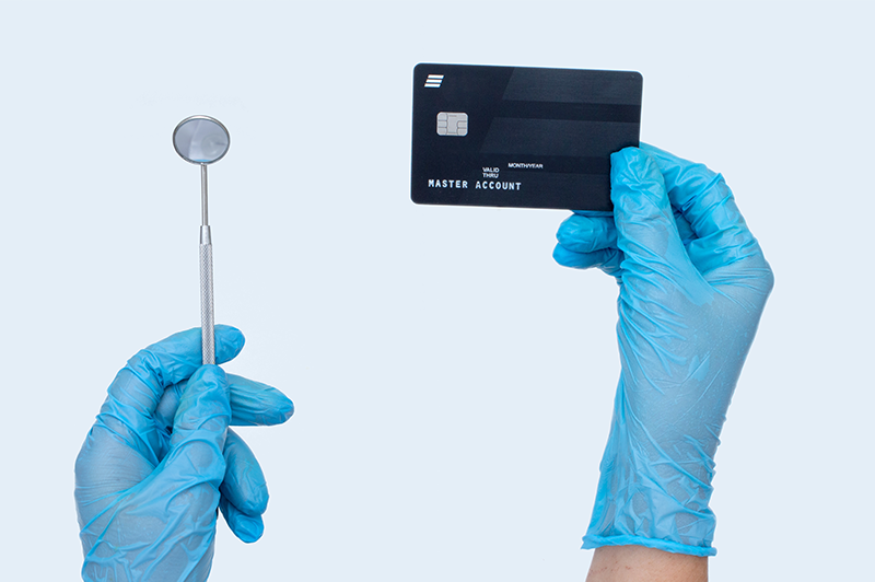 Dentist holding dental tool and a medical credit card
                                           
