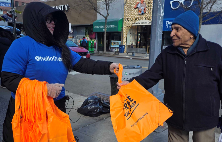 NYC Free Tax Prep volunteer gives information about the NYC Free Tax Prep program to a New Yorker.
                                           