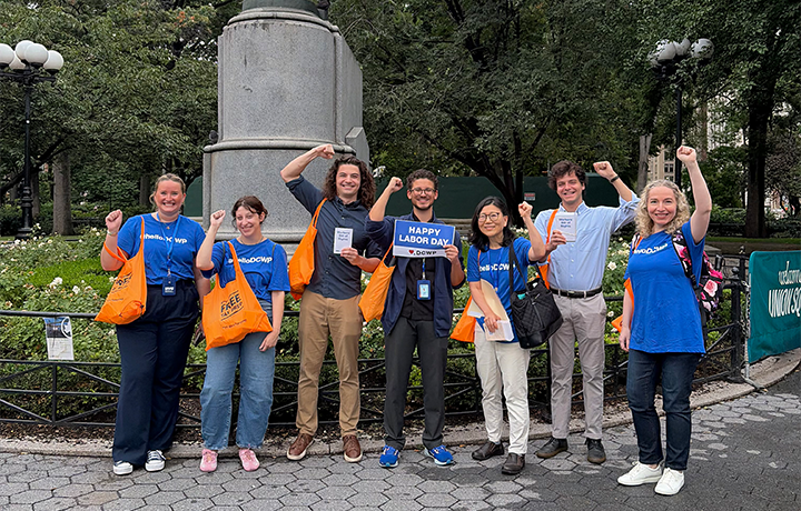DCWP staff members hold a sign displaying 