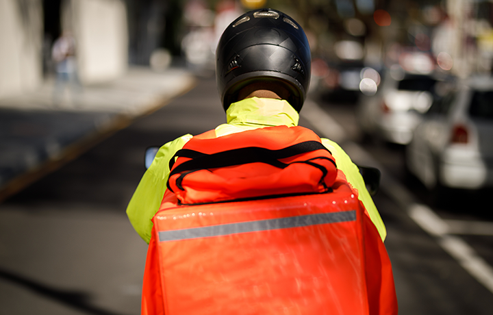 Back of delivery worker with orange pack
                                           