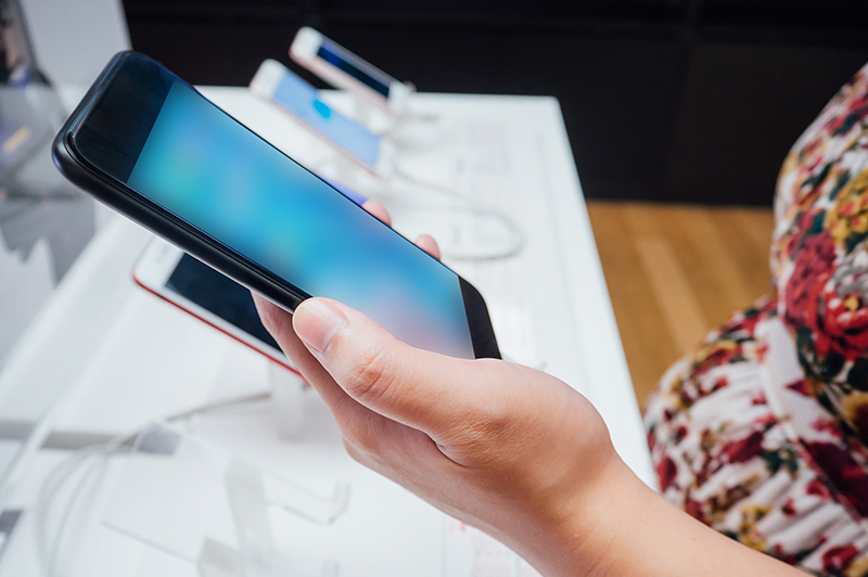Consumer shops for a smartphone in a store.
                                           