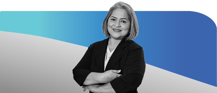 Older woman smiling wearing blazer with arms folded