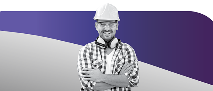 Smiling skilled tradesman wearing hardhat, and safety headphones